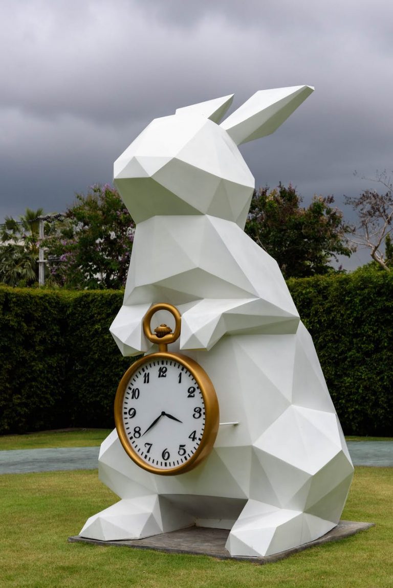 white rabbit holding gold frame pocket watch statue